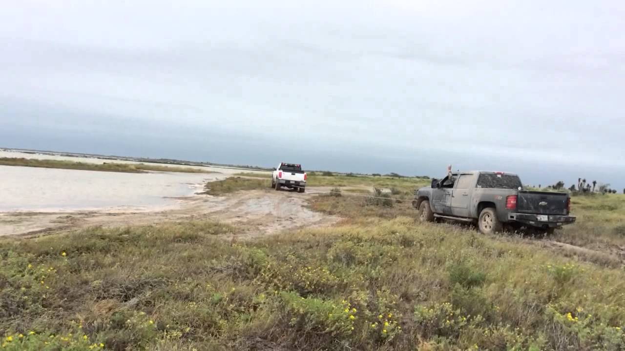 Duramax pulling out a Silverado stuck in the mud - YouTube