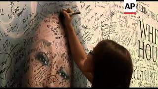 Fans of singer Whitney Houston write condolences on a tribute wall