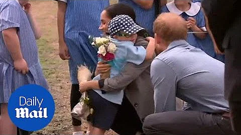 Adorable moment Harry and Meghan receive hug from young child