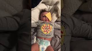 Guy throws American Cheese at baby laying on bed