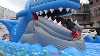 Children eating giant inflatable whale slide with mobile mouth