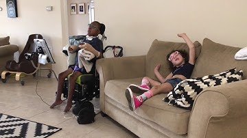 Angela initiating conversation using a hand raise and PODD with auditory scanning