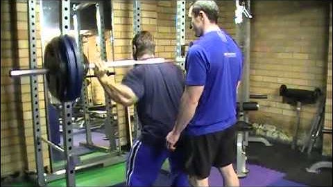 Lee Priest doing Barbell Squats in Powertec Power Rack