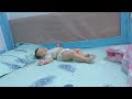 Baby Minh lies down and plays on the blue bed