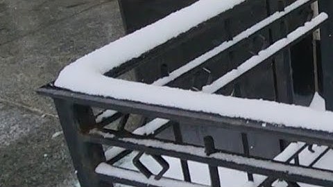Removing Snow From Black Walkway Railing