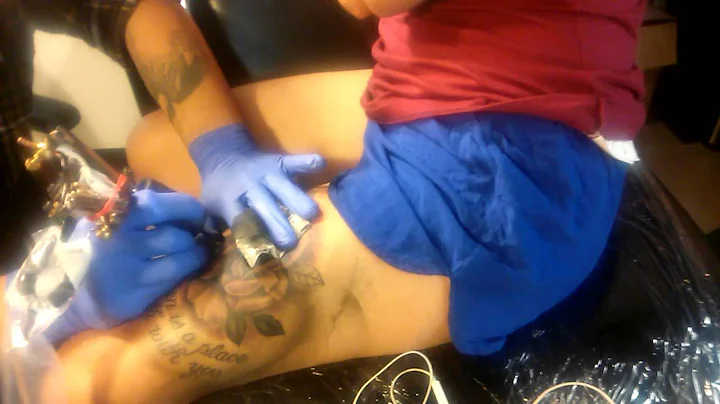Alex Kuo of AK Irons tattooing a black and grey re...