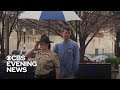 Stranger holds umbrella for sheriff's deputy saluting fallen officer