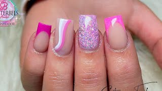 Pink French acrylic nails with glitter and swirly nail art