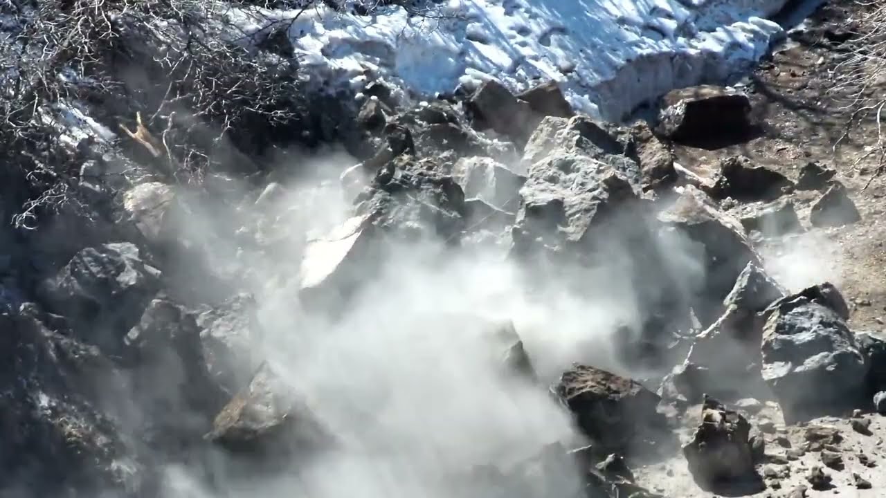 Video, set to Looney Tunes theme song, shows boulder being blasted to bits