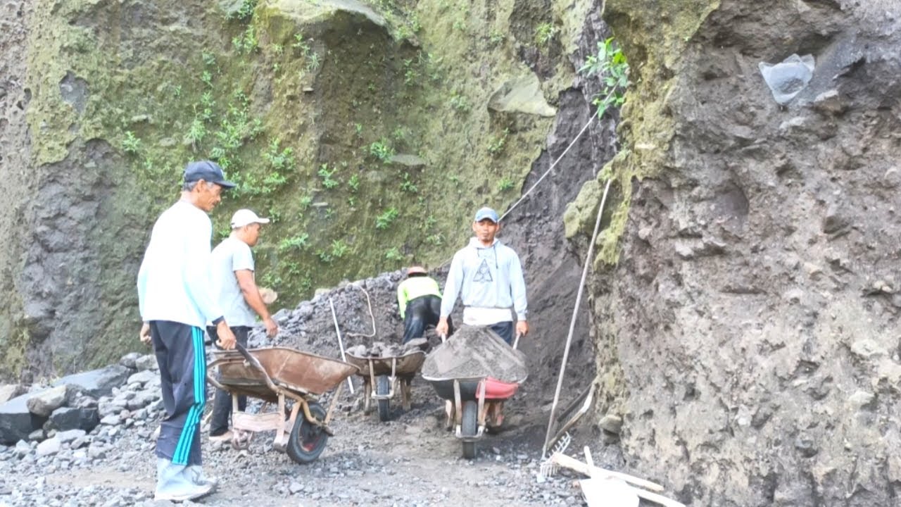 Manual sand filtering process on the edge of the cliff by miners