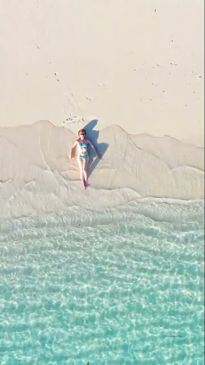 Woman lying back on white sand beach Maldives #shorts