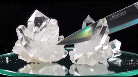 Razor-sharp blade slicing minerals—obsidian, quartz, sapphire—showing true fracture and optical effe