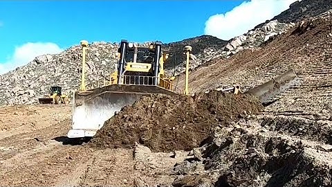 CAT D8T Dozer cutting slope and ripping away