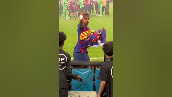 Lamine Yamal cogiendo una bandera del Barça de la grada tras la final de la Supercopa