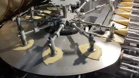 Automatic ice cream cone machine with paper sleeve dispenser.