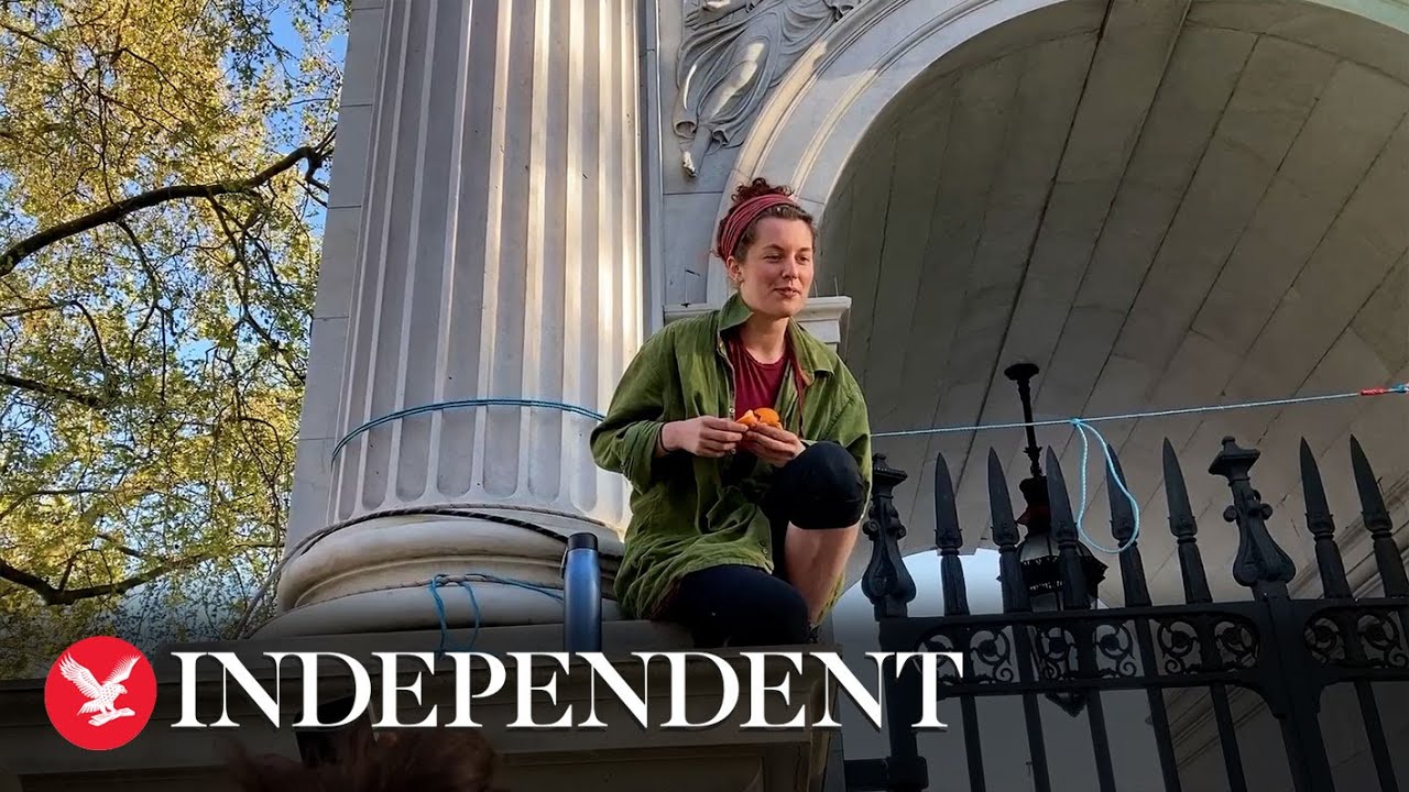 Extinction Rebellion protesters scale Marble Arch to hoist a banner