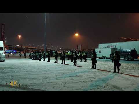 Ottawa: Cop line guarding fuel cans in preparation for removal by hazmat crews 2-6-2022