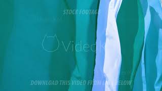 Multicolored silk green and blue flags are waving on a wind in slowmo