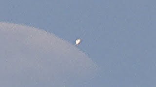 Shining UFO flies during my daytime filming of the Moon in Moscow.