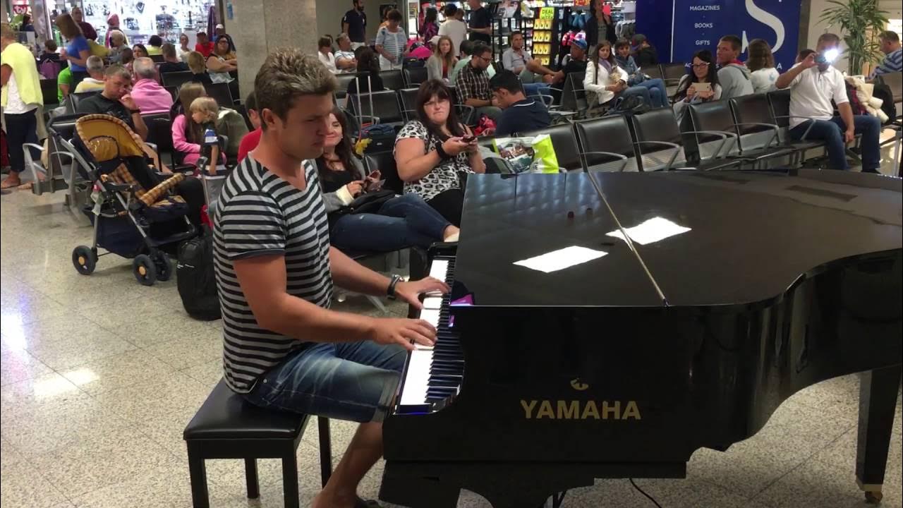 Парень играет в аэропорту. Парень играет в аэропорту. Игра на фортепиано в аэропорту. Игра на пианино в аэропорту. Игра на пианино в аэропорту.