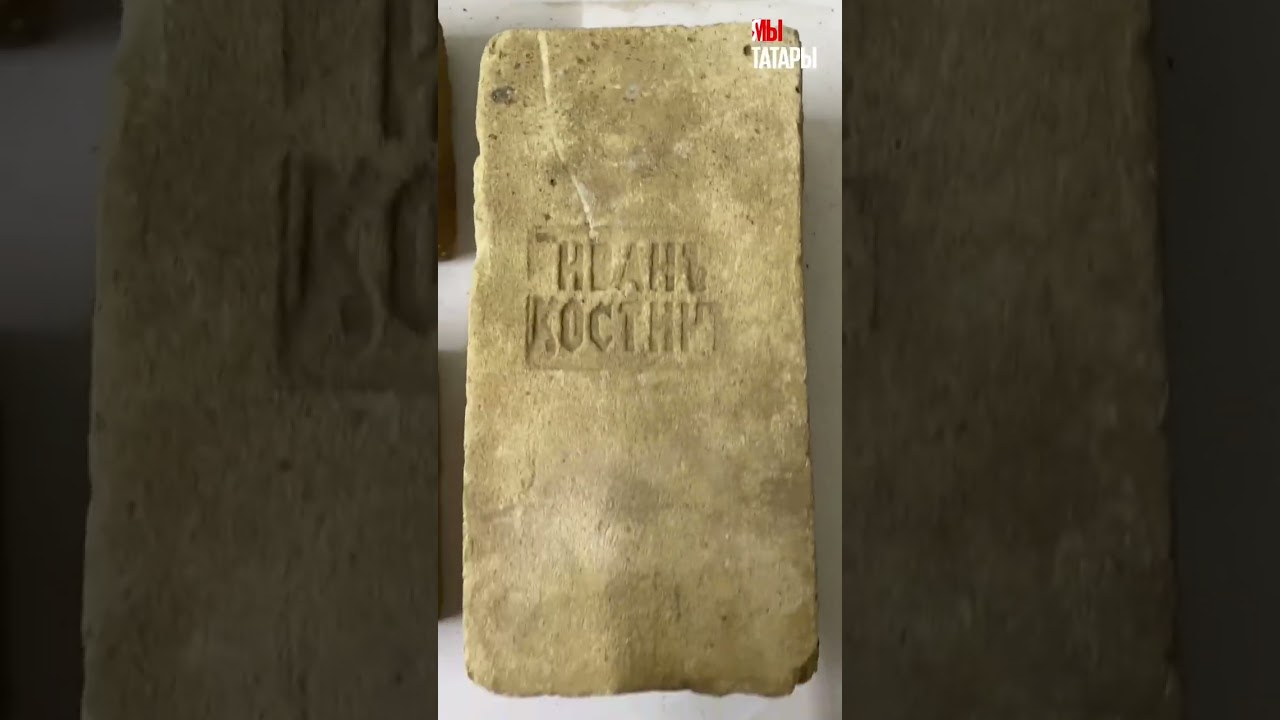 Археолог показывает старинные кирпичи с клеймами, созданные во второй половине XIX века