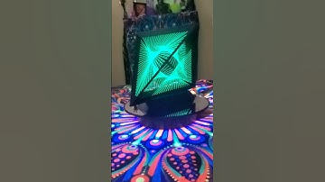 String art sculptures fluorescing from a blacklight.