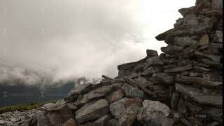 rocky high top of the mountain with fast moving clouds. sunset after the rain. smooth movement