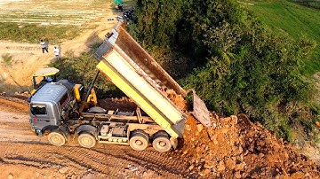 Excellent job operator bulldozer working push soil build New Road/Heavy dump truck unloading soil.