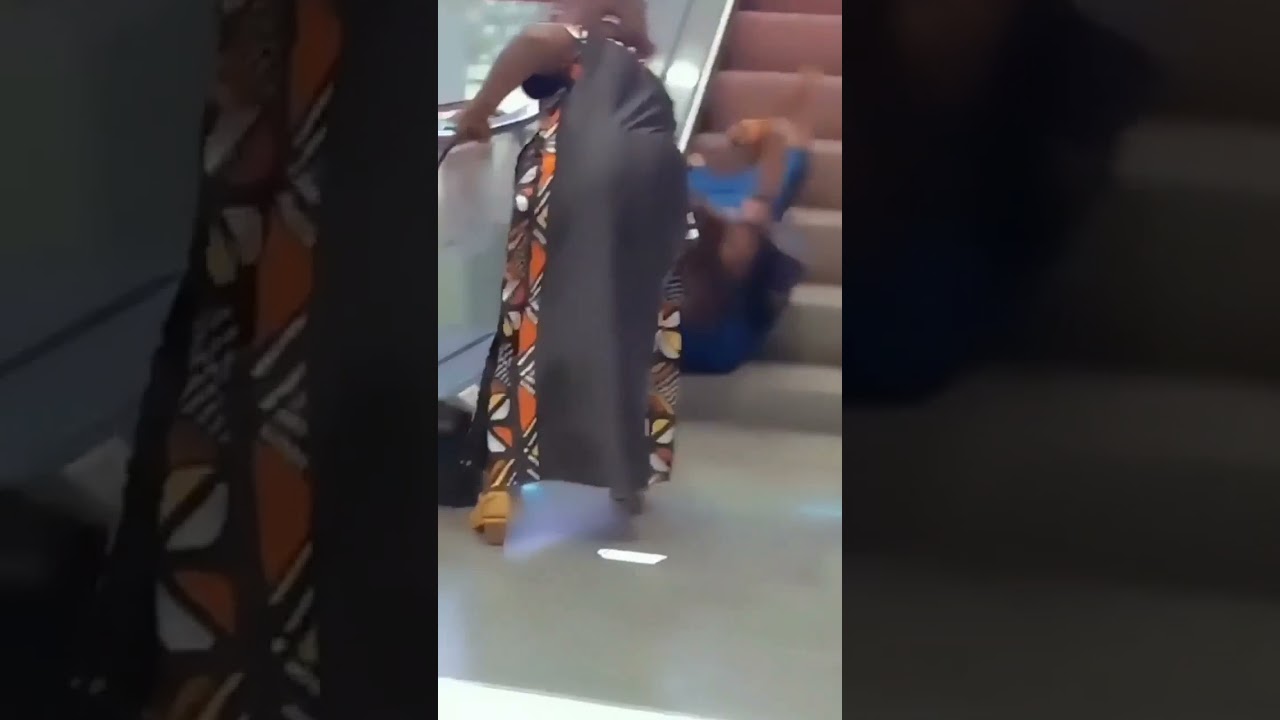 A woman in high heels has lost her balance and fallen down an escalators 