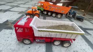 The tractor's trolley tipped into a hole while unloading sand.