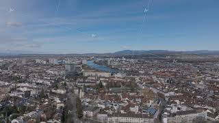 Forwards fly above buildings in town. Panoramic view of city with river and bridges. Basel