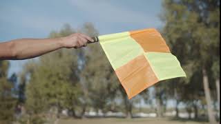 close up of raised flag for offside of assistant referee during soccer game over