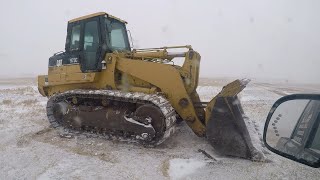 Blizzard conditions clearing land CAT 973C Track Loader