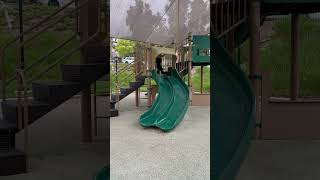 Boy hang on roof of slide and swings himself onto edge of slide and hits sensitive area