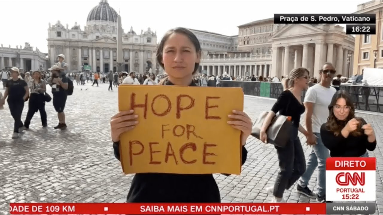 Yona Tukuser holds a "HOPE FOR PEACE" sign in St. Peter's Square at the Vatican during the Conclave