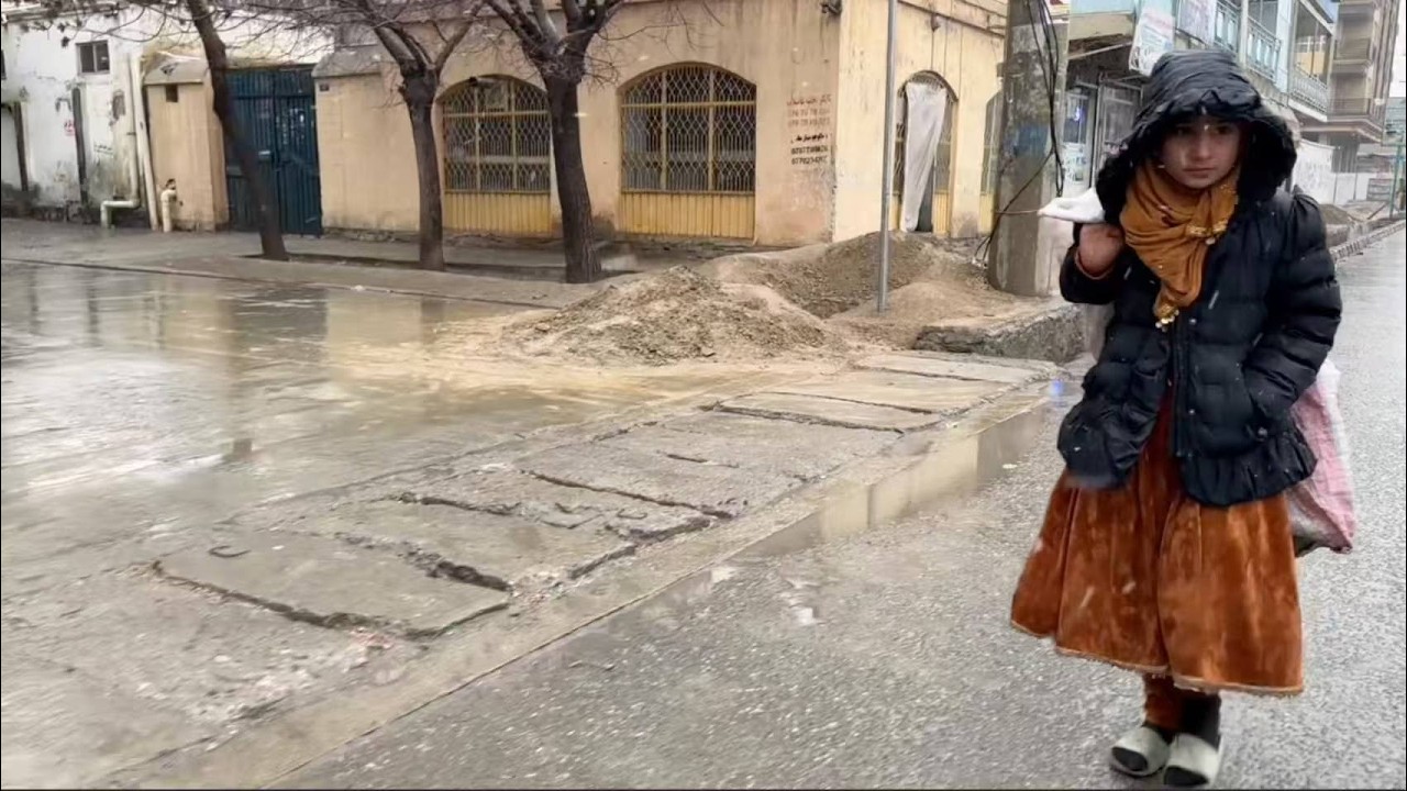 При температуре -17°C афганская девочка, в рваных тапочках и тонких носках, ищет объедки, ее губы...