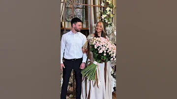 Groom Presents A Large Bouquet Of Flowers To The Bride 