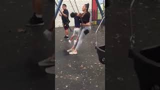 Lady sits on swing with kid and they both fall back
