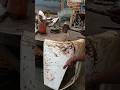 HAMMERING TRUCK'S FENDER IN MECHANICAL WORKSHOP USING STEEL TABLE SUPPORT