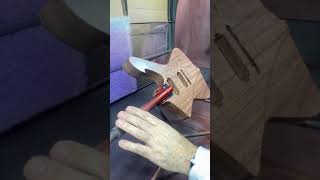 An Iceman guitar body gets a copper sparkle finish but first a sealer coat of white.