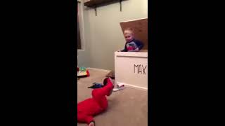 Baby hides in toy chest and sneaks up on his brother