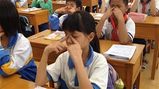 طلاب صينيون يحاولون إراحة أعينهم بالتدليك
