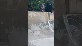 Little girls dops into quarter pip at skatepark on her scooter then falls forward and bumps head