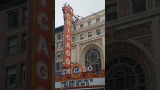 Handheld shot showing famous Chicago Theatre marquee with flashing lights on North State Street