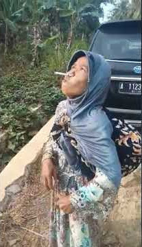 Aksi nenek nenek merokok pakai hidung.