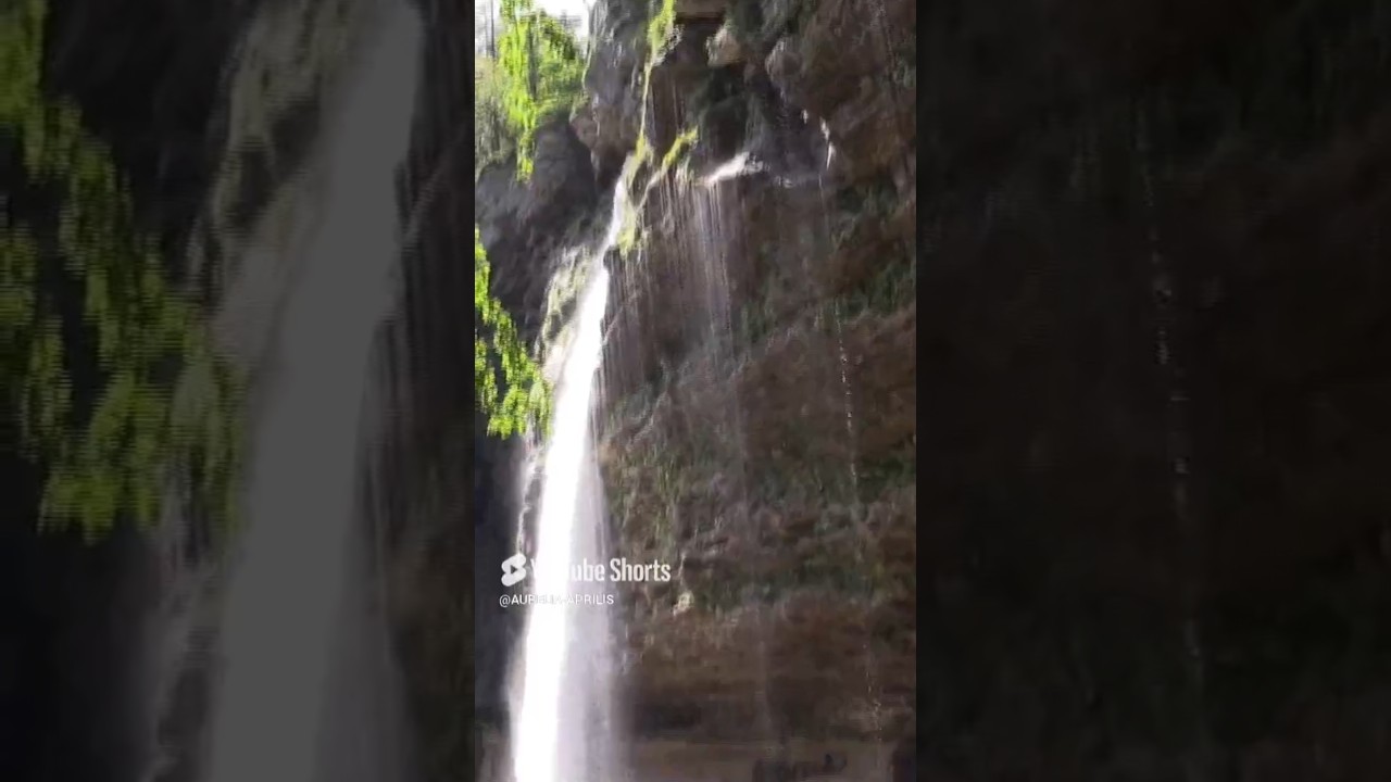 WATERFALL. Forest close to waterfall and mountains around.