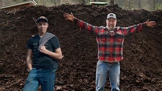 (Family Life) Father and Son working together to spread compost on pasture