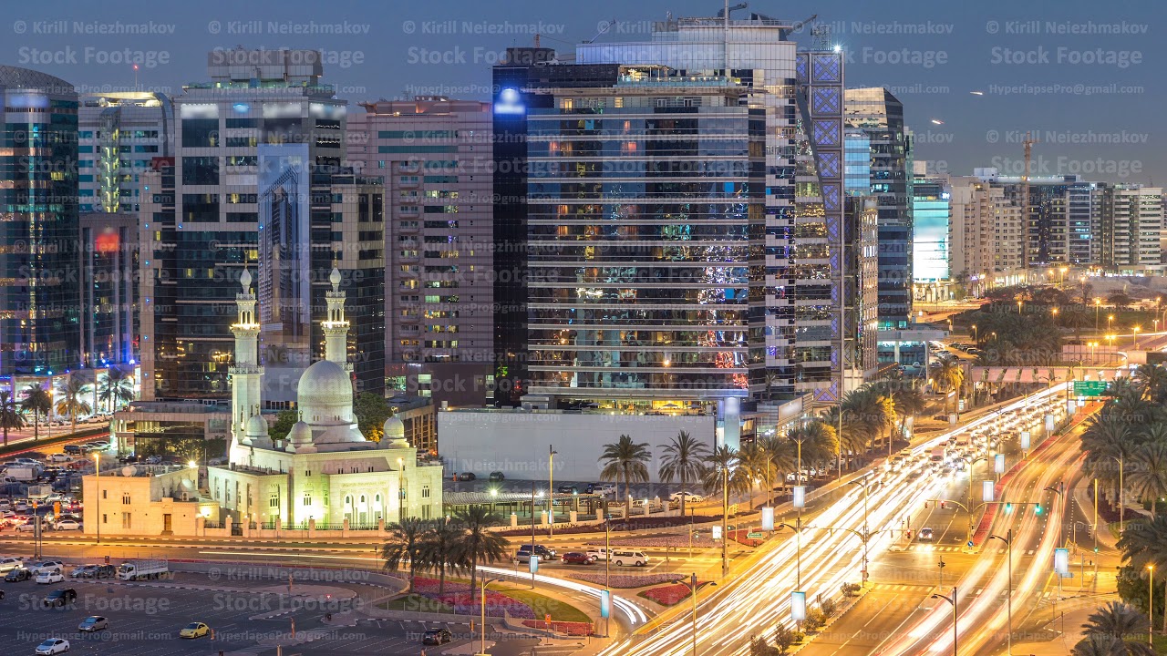 Mosque near Dubai Creek surrounded by modern buildings and busy traffic street day to night
