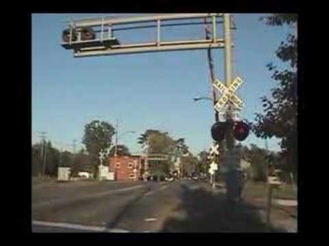 This is the video of the Ford Avenue Crossing in Wyandotte, Michigan. This crossing is 1/2 mile away from the Vinewood Avenue crossing. The crossing features 8-inch Harmon Electronics Lights, GS Electronic Bells. The gate mechanism is on its last leg, as the maintainer sprayed something into the motor, and it was hot, which caused it to catch on fire. Suprisingly, the motor still works.