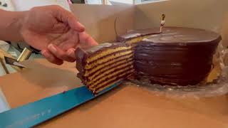 Cutting Miss Mary Ada's Smith Island Cake at Drum Point Market on Maryland Crab Cake Tour Day 22